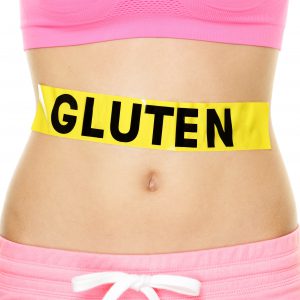Gluten allergy, health and Celiac disease and digestion concept with GLUTEN text written on stomach sign on woman belly. Conceptual food allergies image.